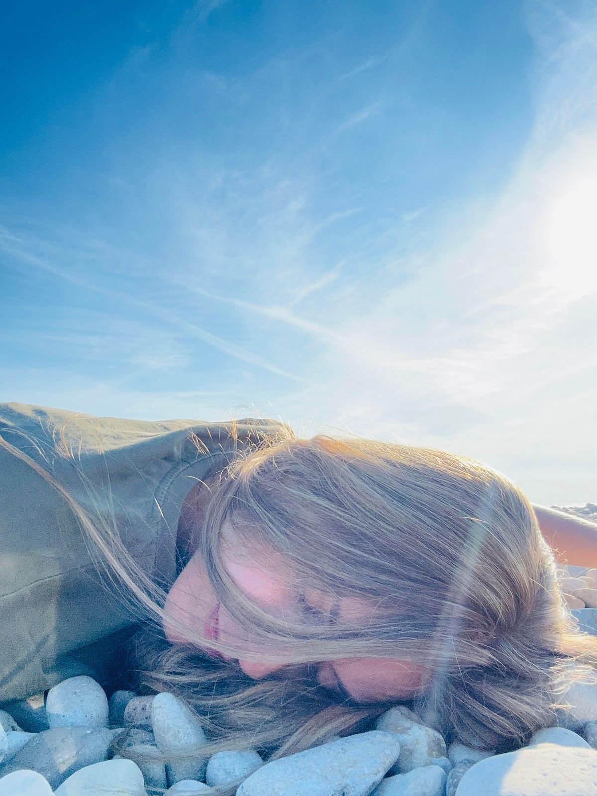 girl on the beach lying on rocks